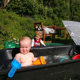 Little girl in a solar powered paddling pool