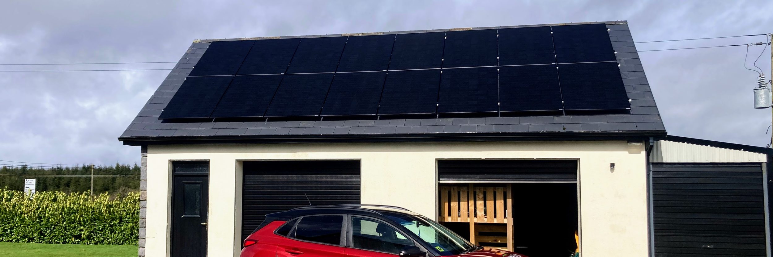 PureVolt vehicle parked outside an Irish home with solar panels on the roof